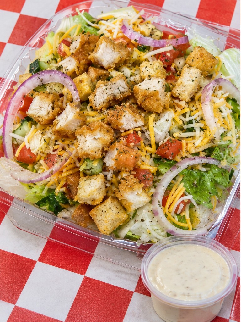 Fried chicken salad with cheese, tomato, onion and dressing
